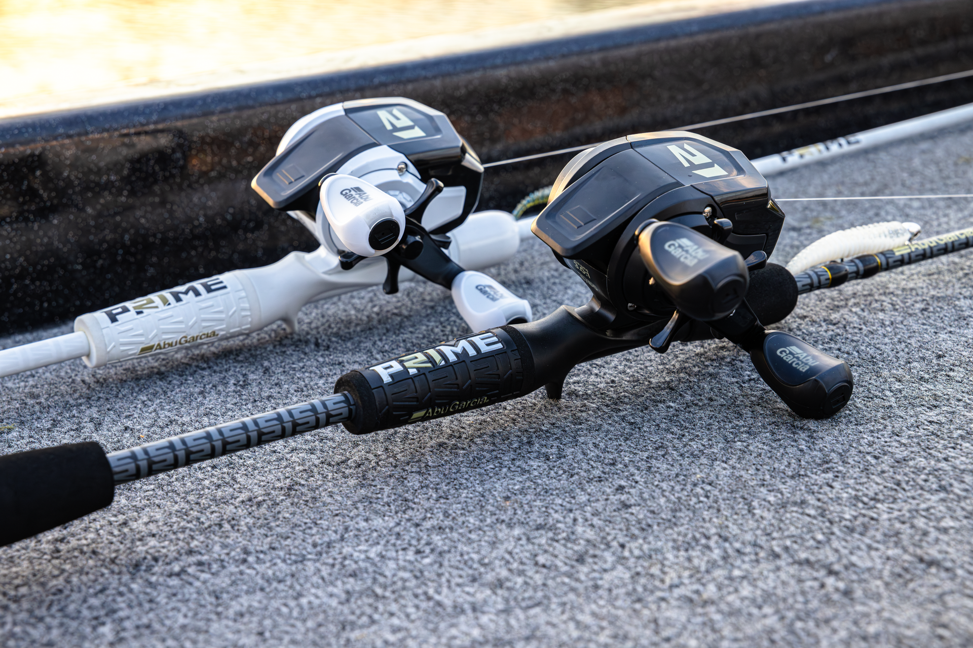 Two Abu Garcia + PRIME21 Collaboration Spincast Combos laying flat on pavement, one black & one white. 