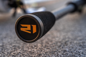 Close-up of the Abu Garcia + PRIME21 Collaboration fishing rod handle with a 21 branded logo on a blurred background