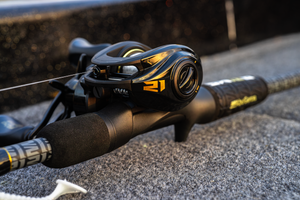 Close up shot of the Abu Garcia + PRIME21 Collaboration Baitcast Black Combo on the pavement. 