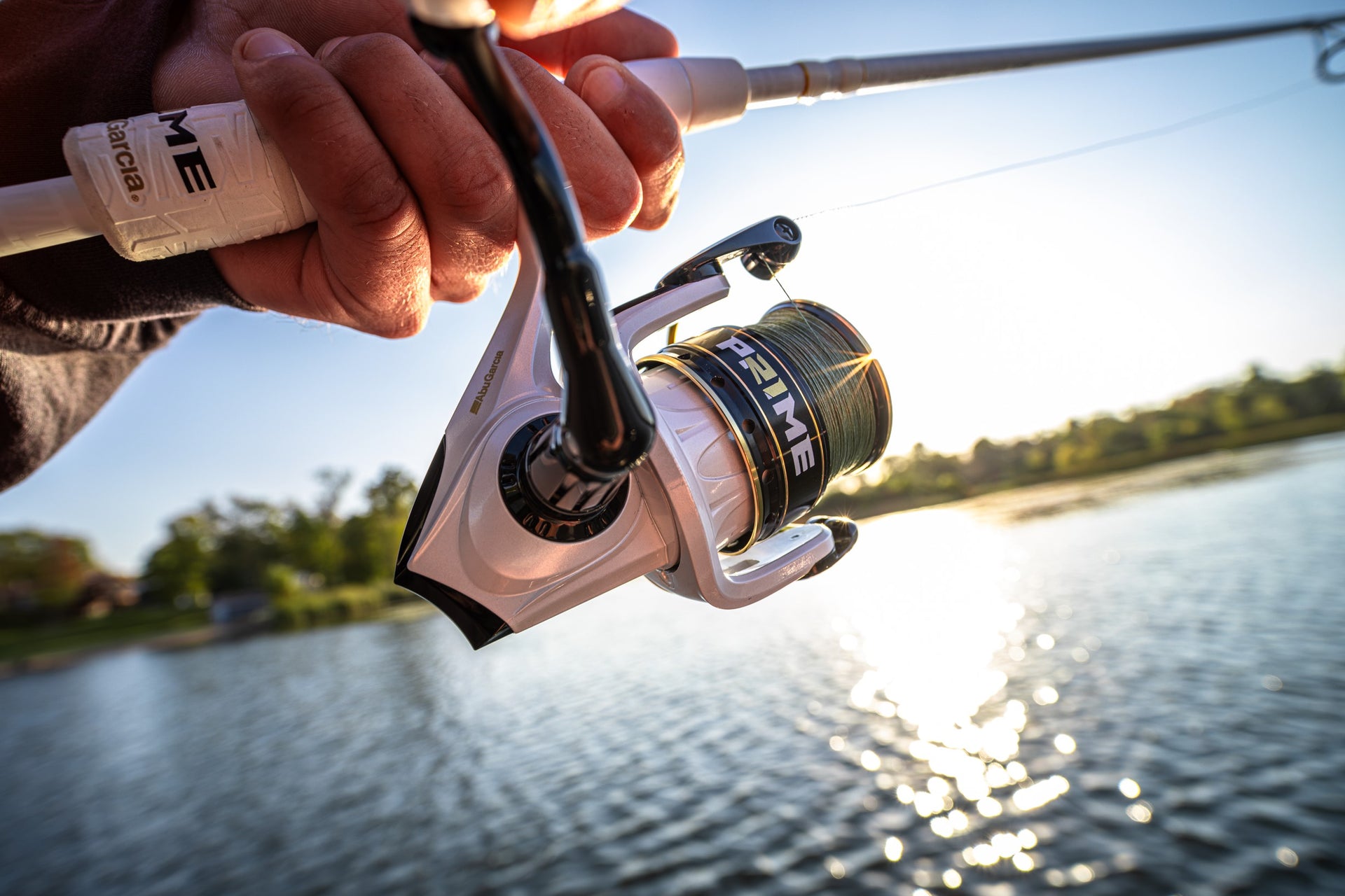 Close up of a Abu Garcia x PRIME21 Spinning Combo in man's hand over water