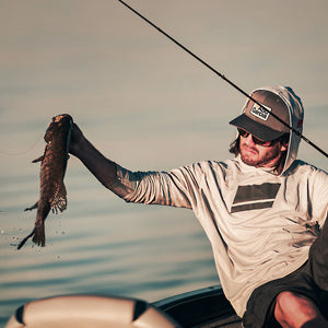 Man on a boat holding a fish with a blurred background