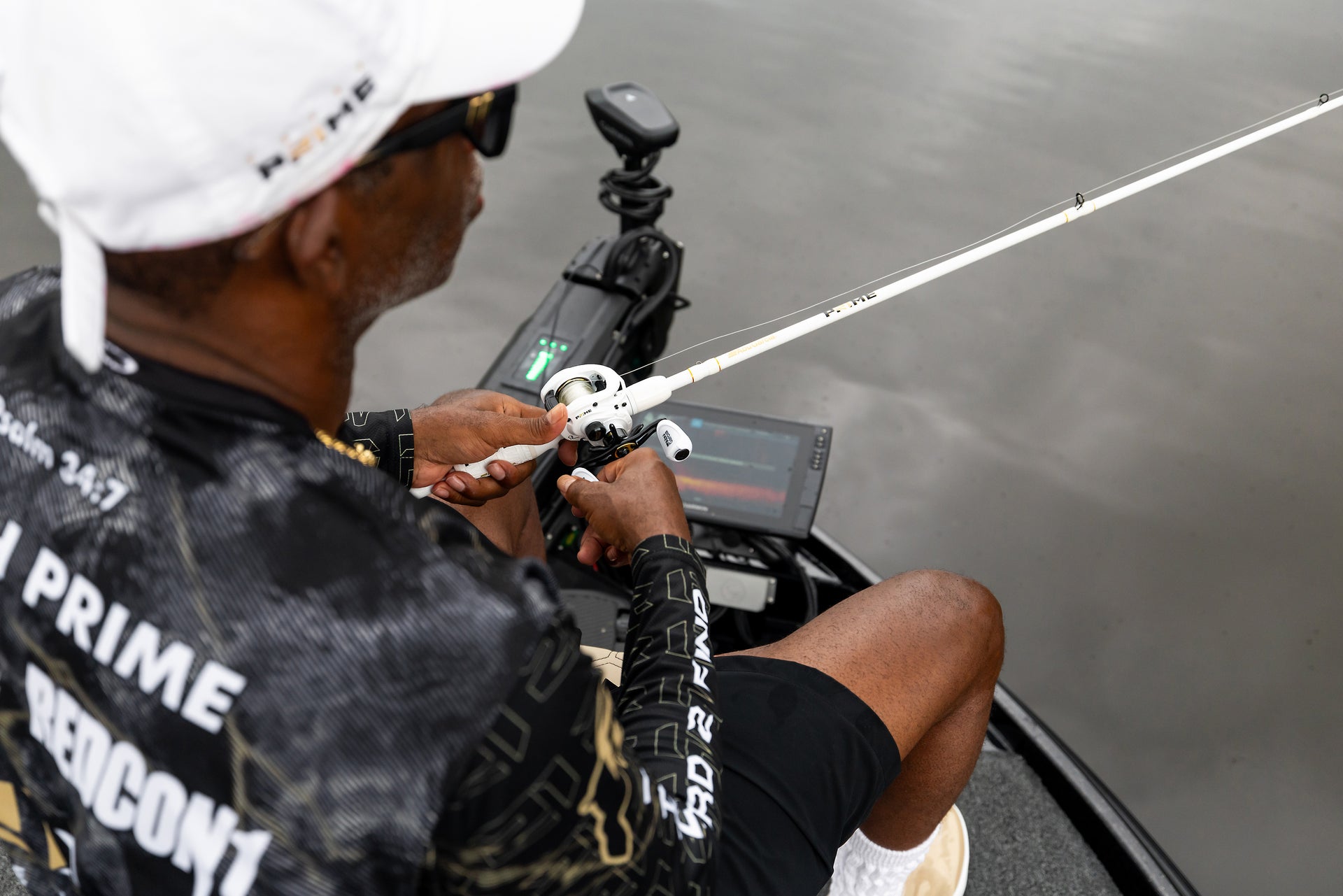 Coach Prime fishing from a boat, wearing a cap and sunglasses with a Baitcast Combo. 