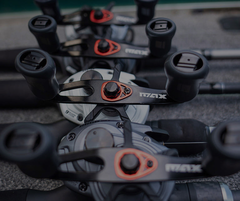Close-up of fishing reels with 'MAX' branding on a textured surface