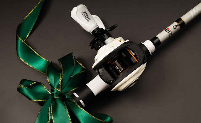 Fishing rod with reel and green ribbon on a dark background