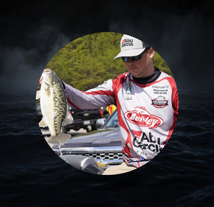 Caz Anderson holding a fish on a boat with Abu Garcia and Berkley logos.