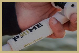 Hand holding a Abu Garcia Prime fishing reel with a blurred background
