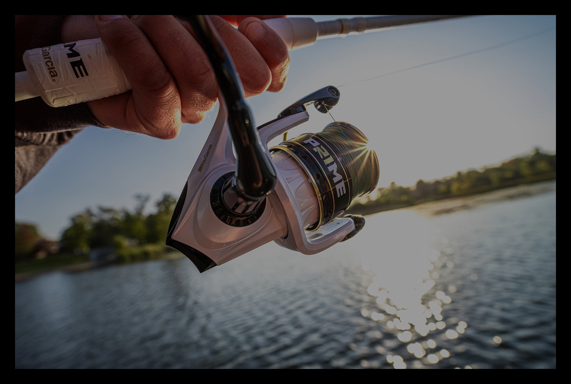 Fishing rod with a reel held by a person over a body of water.