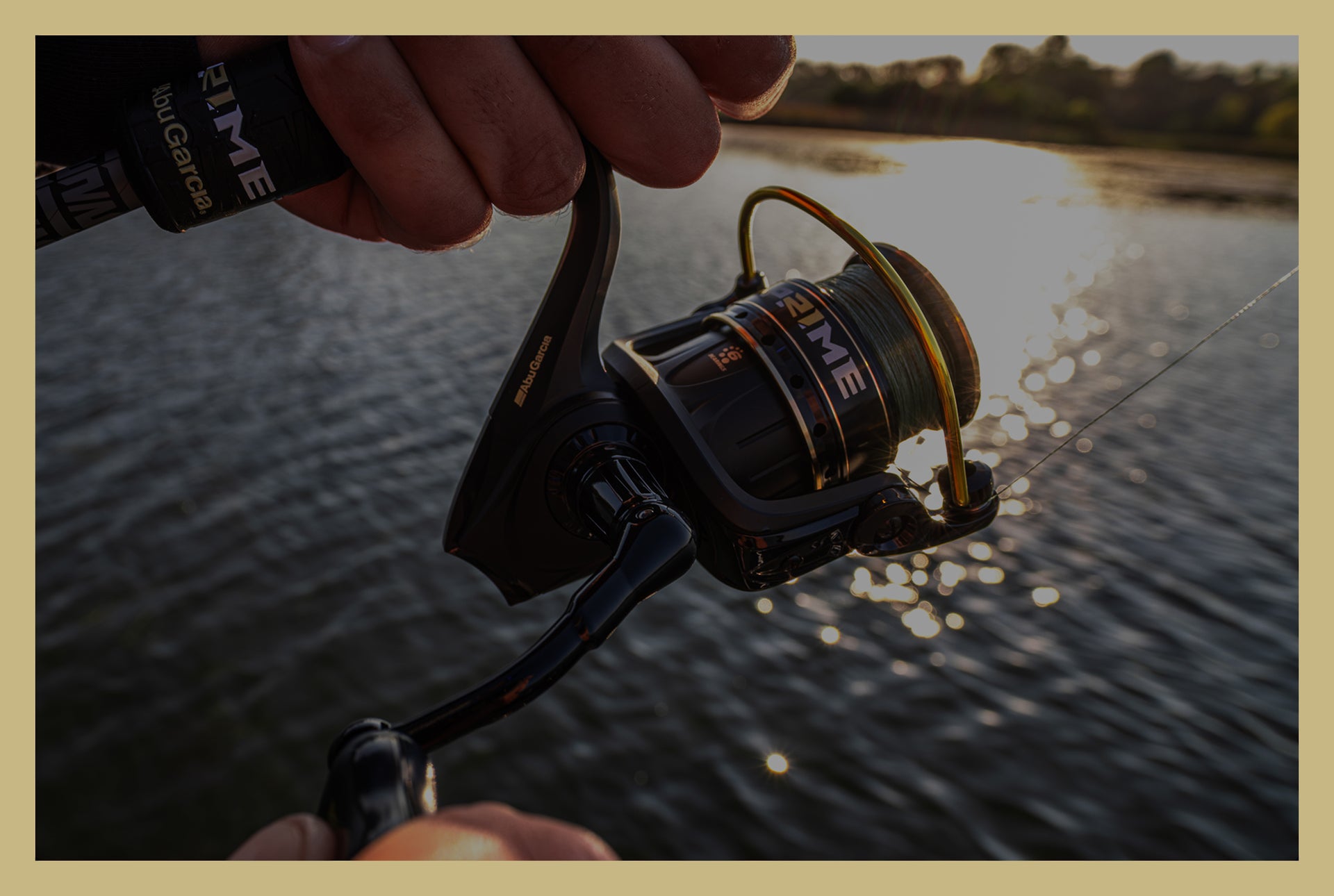 Fishing reel held by a person over a body of water with fishing line visible.