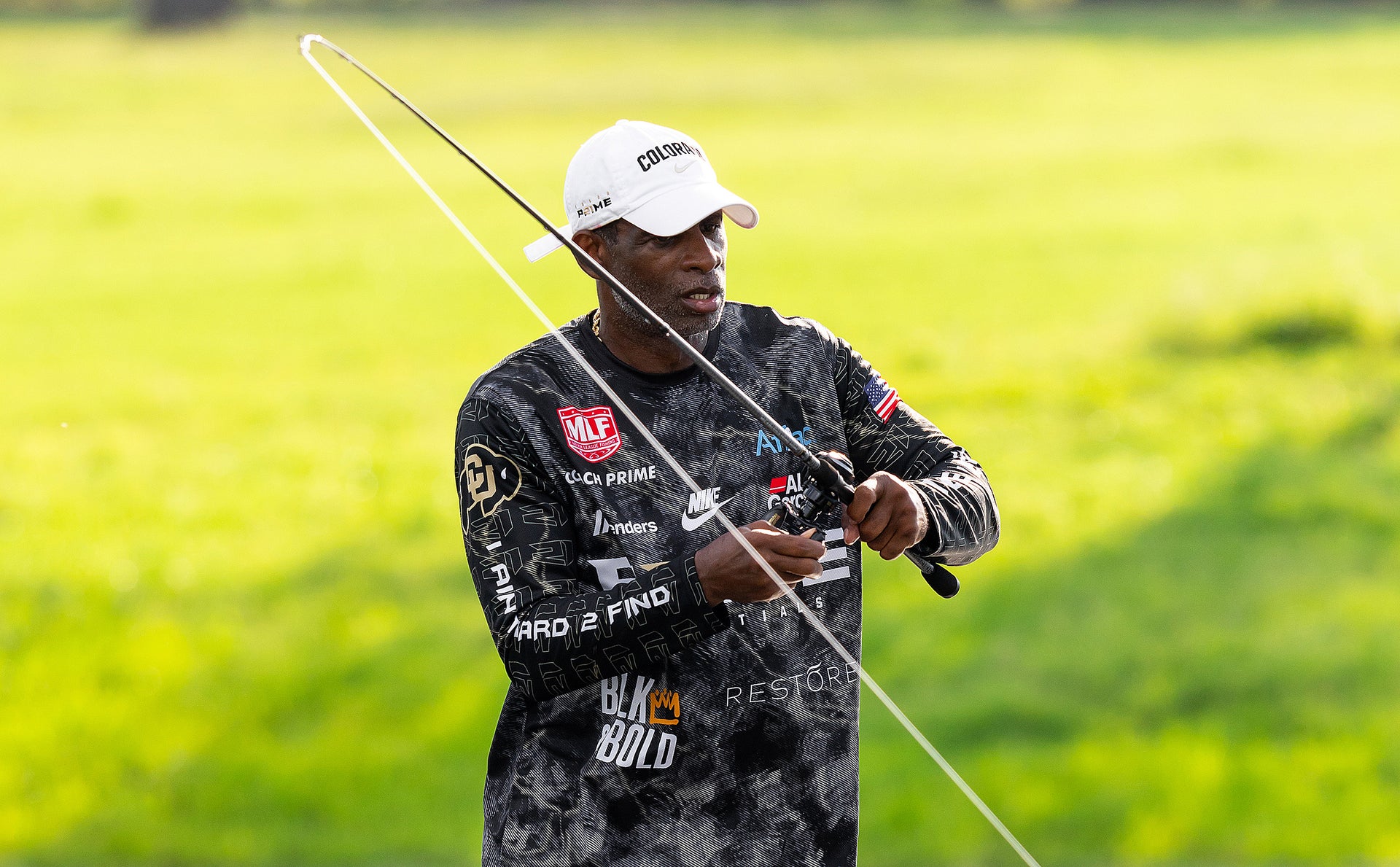 Man holding a bow and arrow in a grassy field