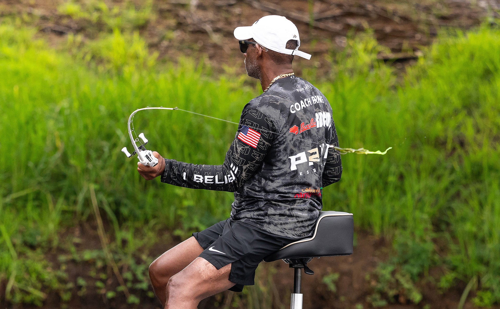 Person fishing from a boat in a natural setting with greenery.