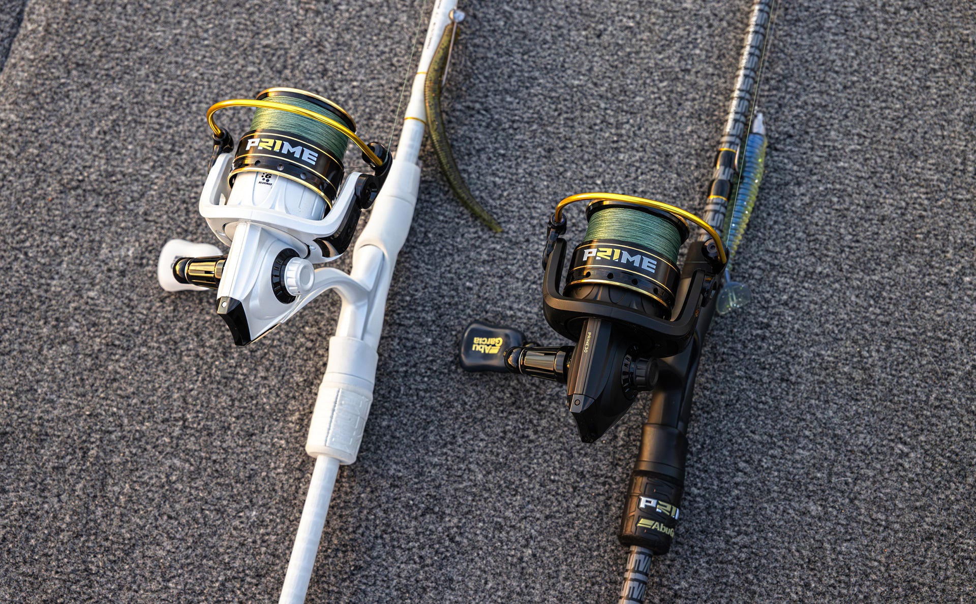 Two fishing reels with rods on a textured surface