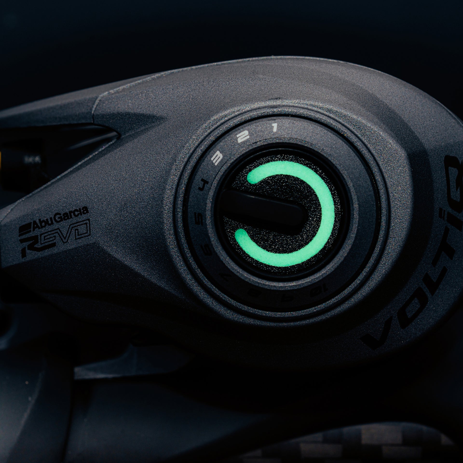 Close-up of a Abu Garcia Revo Salt Pro baitcasting reel with a green display on a dark background.