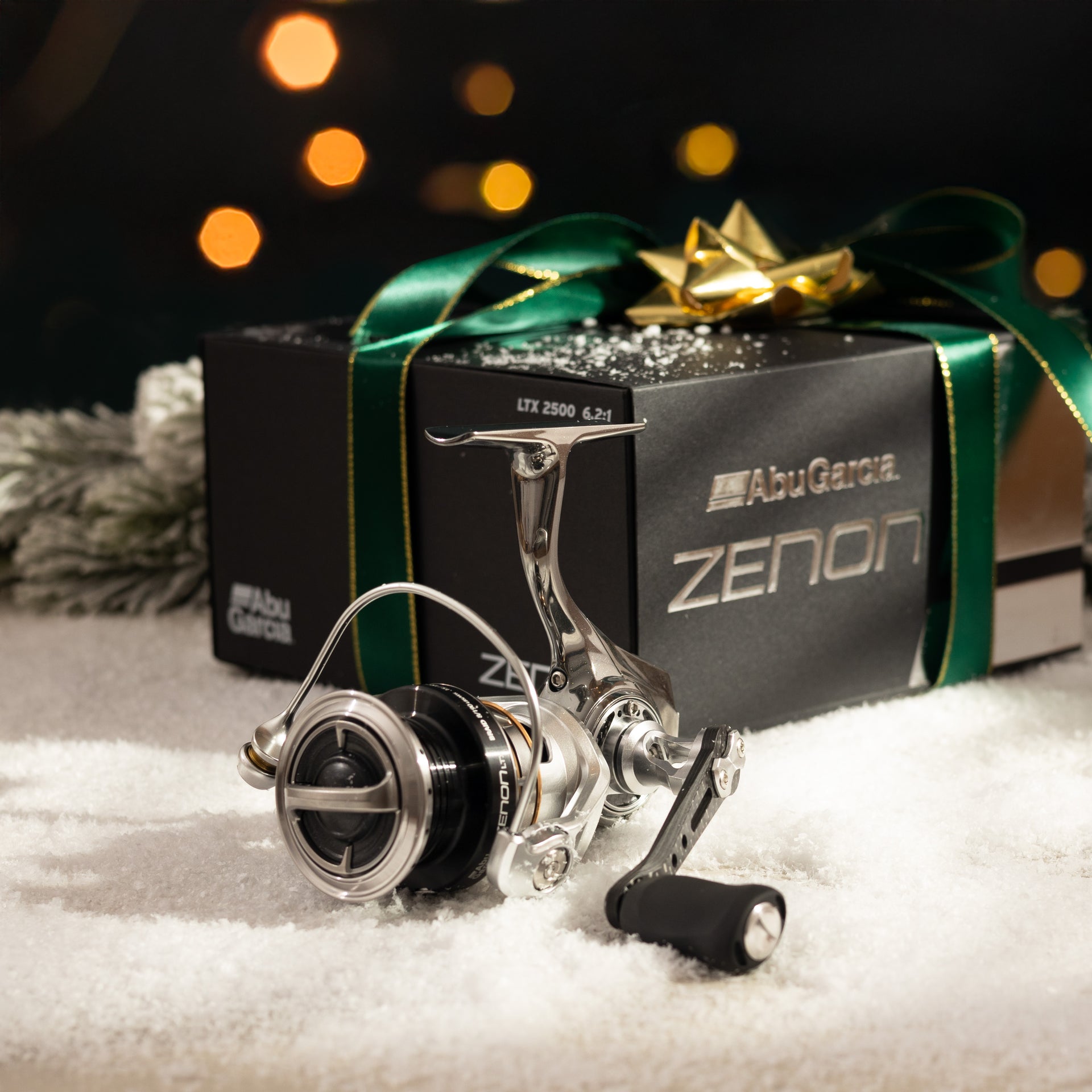 Abu Garcia Zenon Reel with holiday box and bow in background on a snowy ground